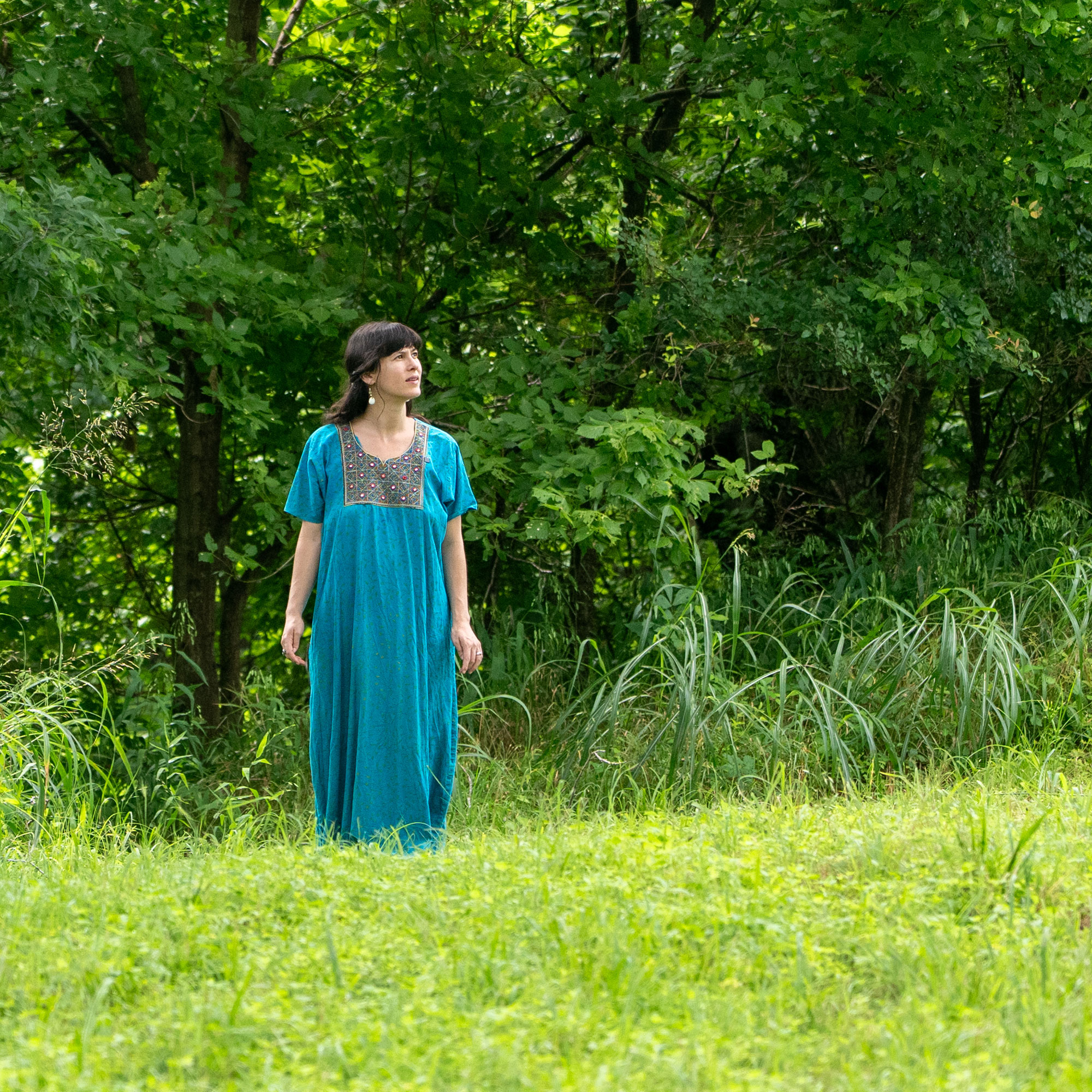Melissa Klein demonstrating ecotherapy through walking meditation in a lush green landscape