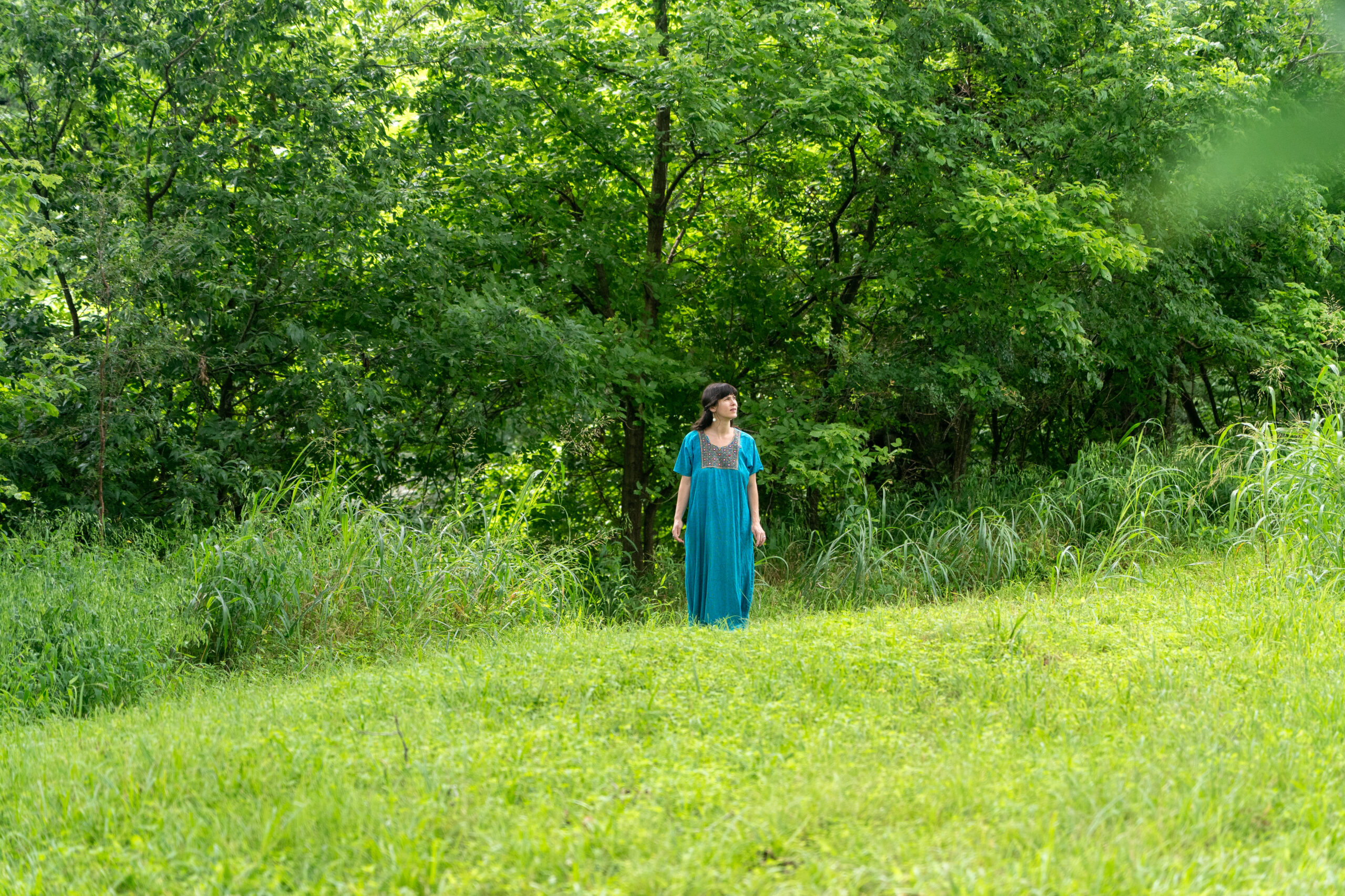 Melissa Klein demonstrating ecotherapy through walking meditation in a lush green landscape