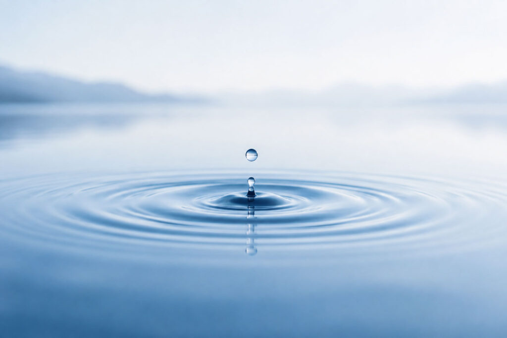 water droplet with ripples and reflection on a clear lake